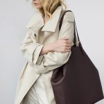 Panama Cabas-Tasche in Burgunderrot, von weiblichem Modell in Businesskleidung mit Mantel in Crème über die Schulter getragen