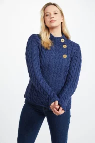 Weibliches Model in asymmetrischer Strickjacke mit Zopfmustern und drei Knöpfen in Persischblau