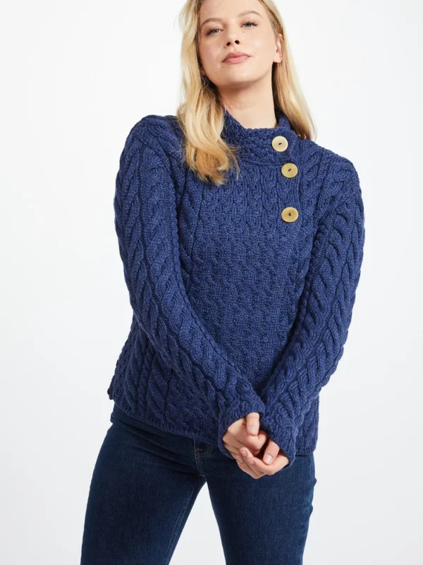 Weibliches Model in asymmetrischer Strickjacke mit Zopfmustern und drei Knöpfen in Persischblau