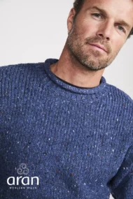 Männliches Modell mit Donegal Tweed Rundhalspullover mit gerolltem Kragen in Denimblau