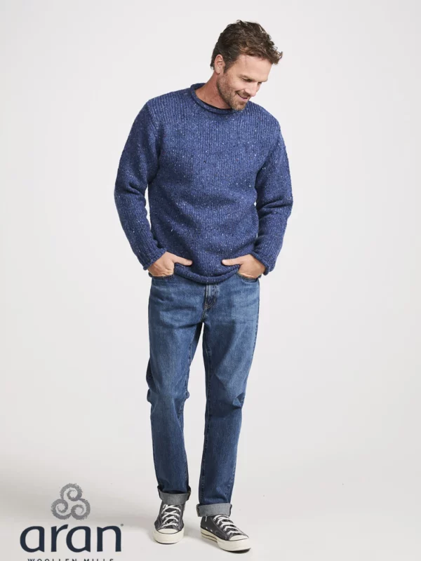 Männliches Modell mit Donegal Tweed Rundhalspullover mit gerolltem Kragen in Denimblau, von Weitem
