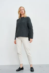 Aran-Pullover in Grau in Kastenform mit Seitenschlitzen. Weibliches Modell mit weissen Hosen trägt Aran Kastenpullover
